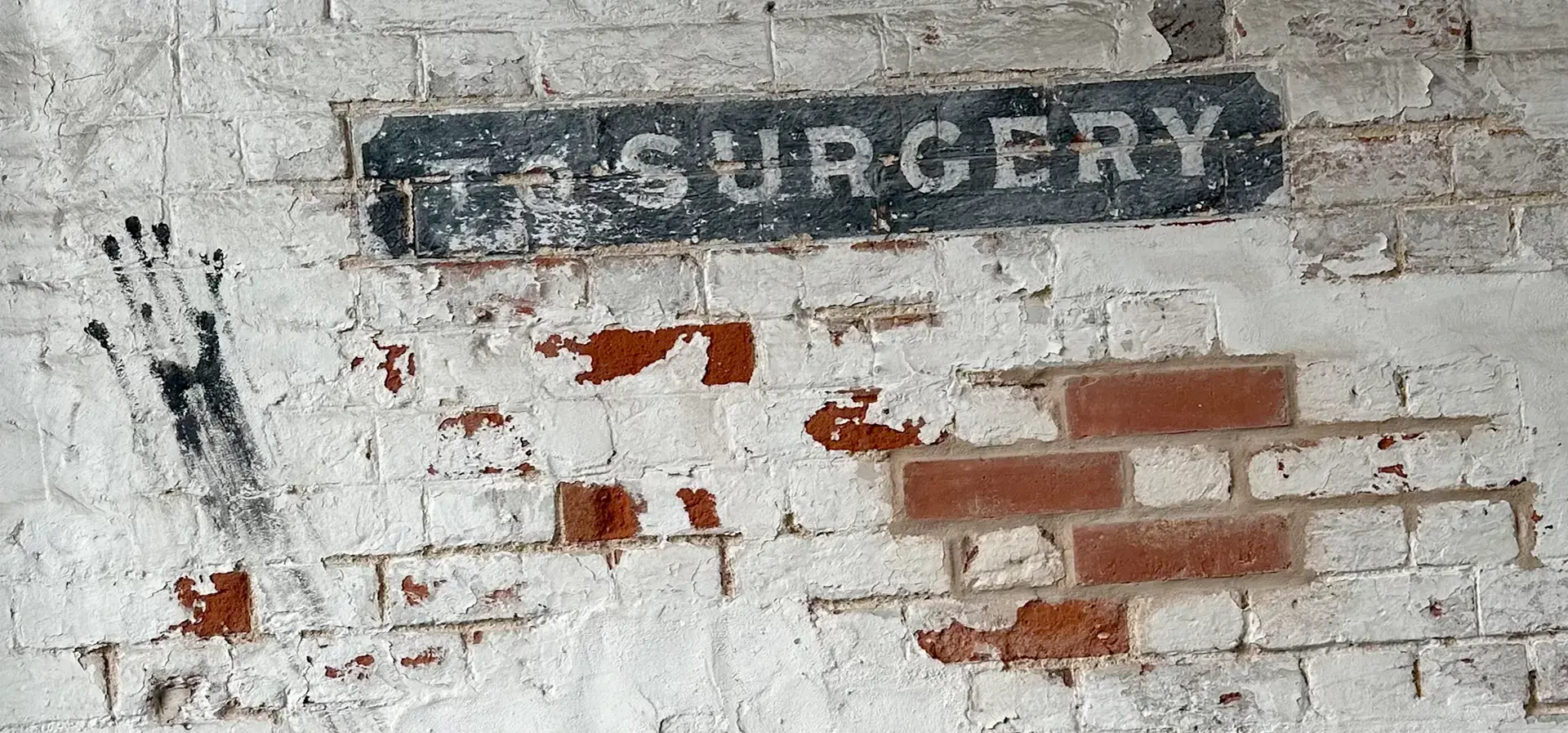 Distressed white brick wall with faded industrial lettering, representing EC2PR’s bold, creative PR and marketing approach.