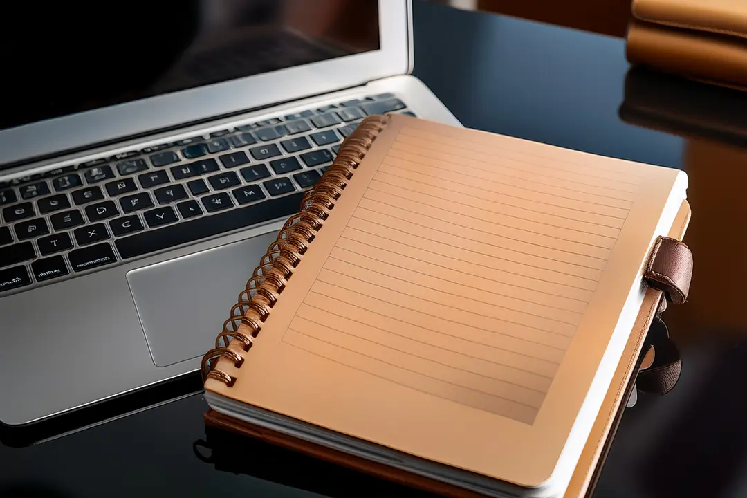 A laptop with a notepad